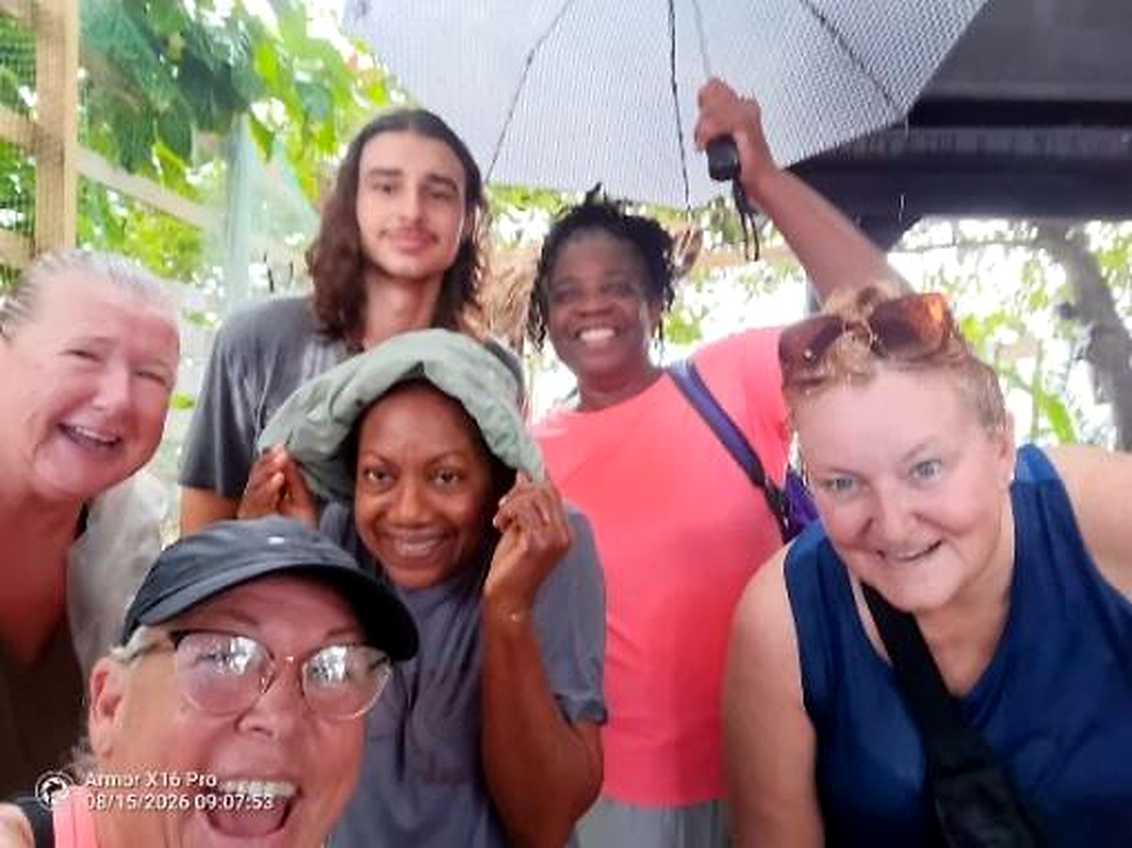 August cleanup volunteers under an umbrella